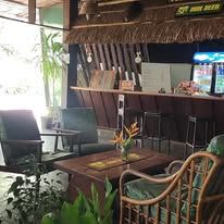 Indoor lounge and bar area with a thatched roof motif and seating.