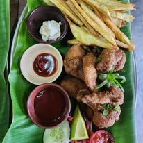 Fried chicken and plantain strips served with dipping sauces and salad.