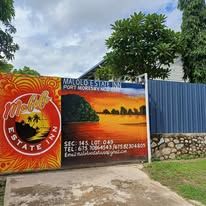 Entrance gate with colorful Malolo Estate Inn signage and sunset mural.