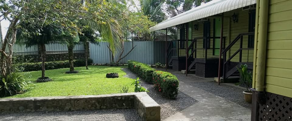 Wooden lodge building exterior with garden lawn and concrete path.