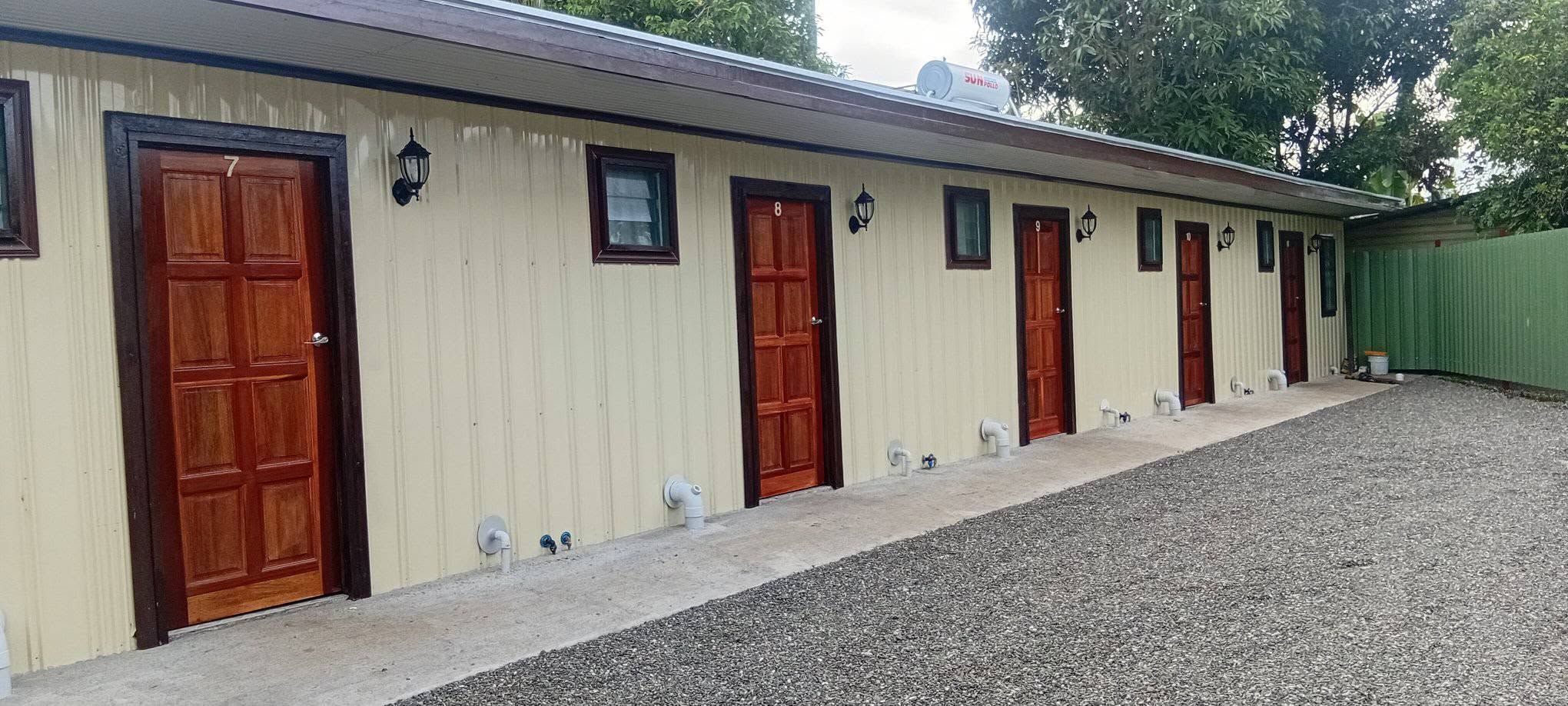 External view of guest unit entrances with numbered wooden doors.