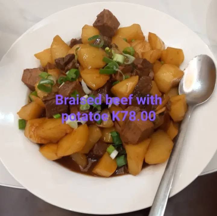 A plate of braised beef with potatoes showing price text overlay.