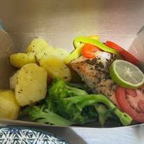 Takeaway food container with grilled fish, roasted potatoes, and steamed broccoli.
