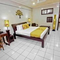 Spacious bedroom with white tile flooring and a dark wood bed frame.