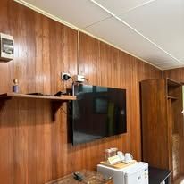 Guest room amenities including wall-mounted television and compact refrigerator unit.