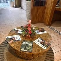 Lobby coffee table centerpiece with magazines and floral arrangement on a round rug.