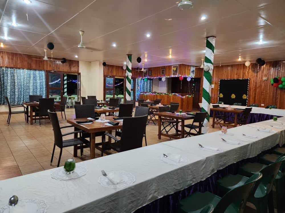 Indoor dining hall set up with tables and celebratory decorations.