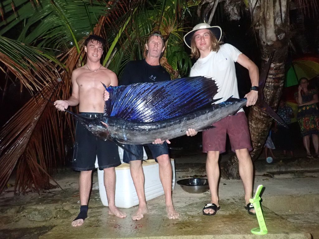 Guests displaying a large sailfish caught during a fishing excursion.