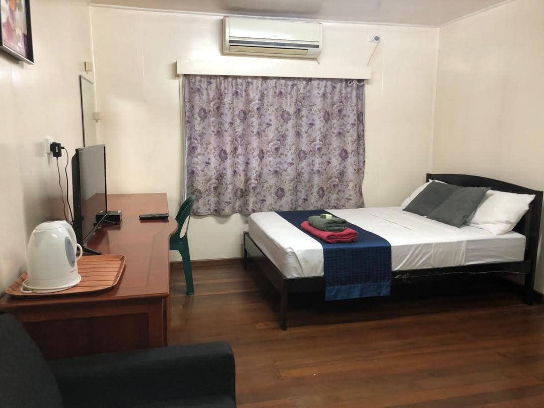 Guest bedroom with double bed, air conditioning, television, and desk area.