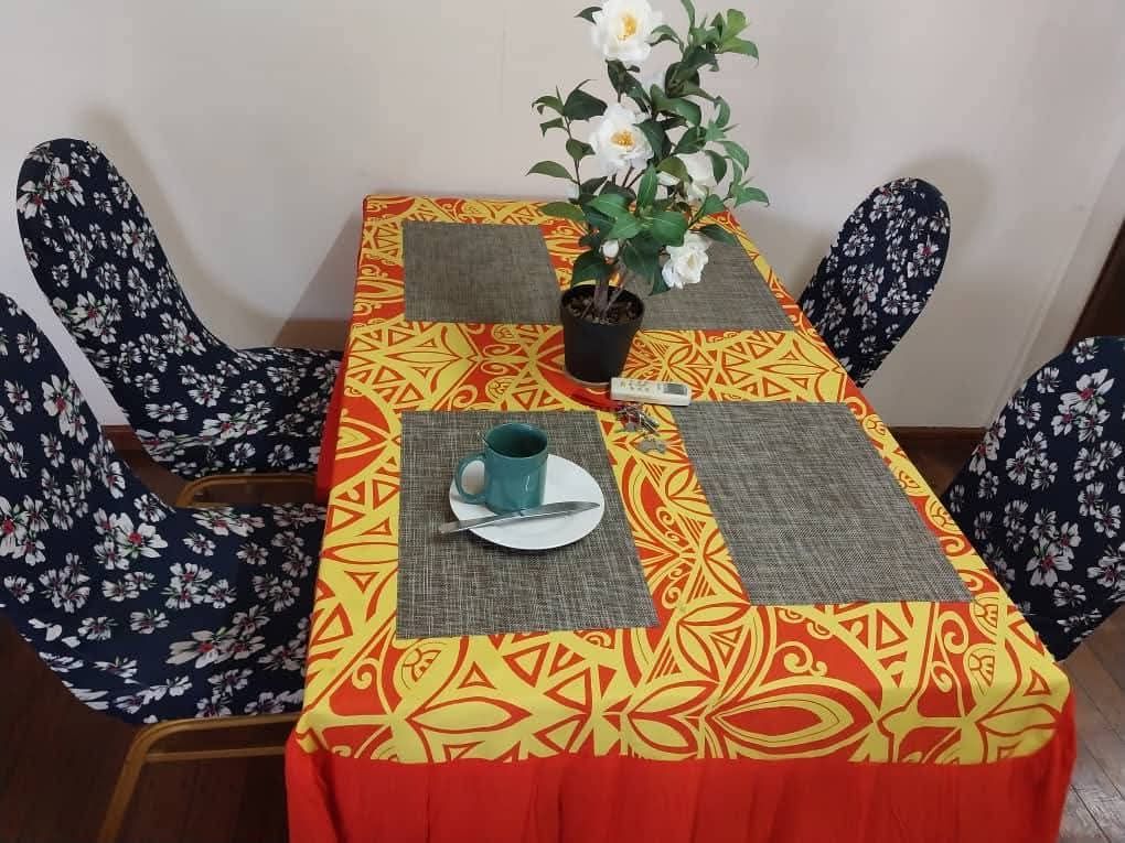 Dining table with floral chair covers and a patterned tablecloth setup.