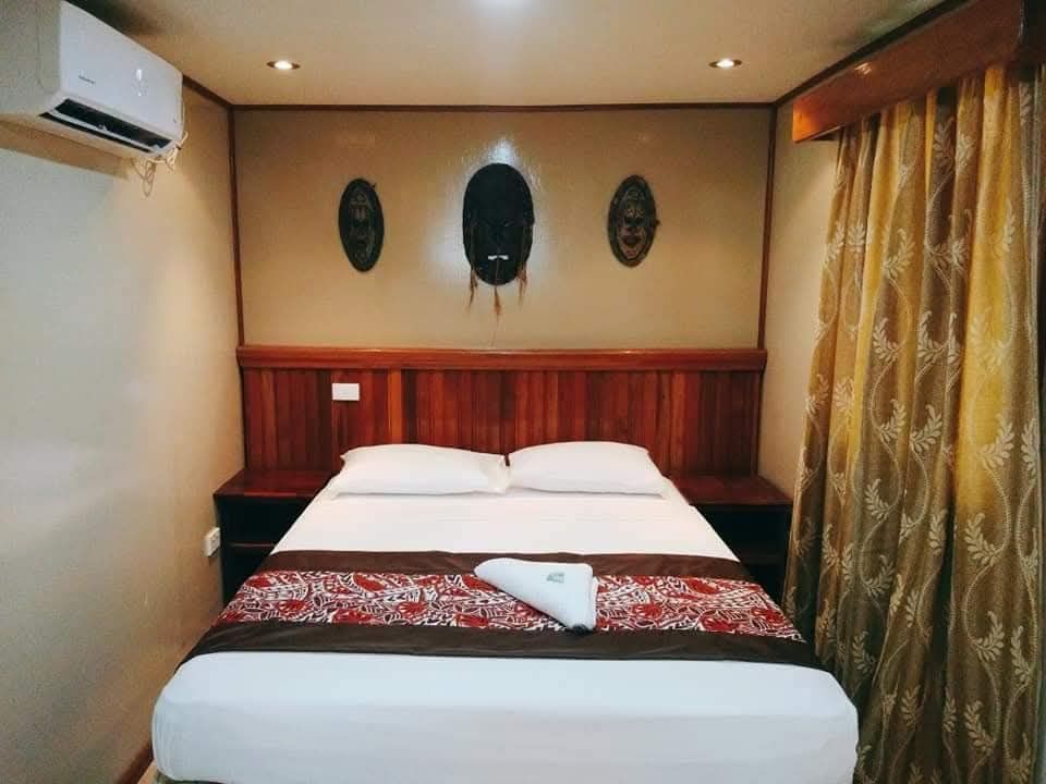 Guest bedroom featuring a double bed with traditional mask wall decor.
