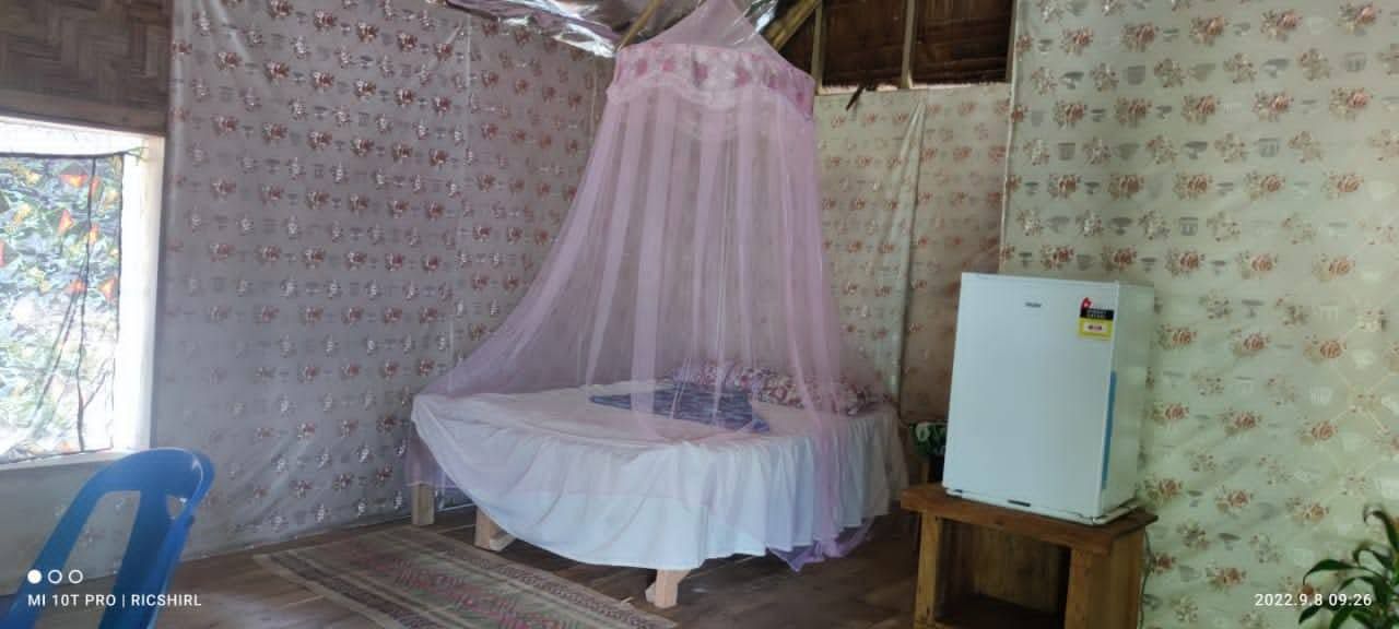 Guest room featuring a cushioned bed under a pink mosquito net.