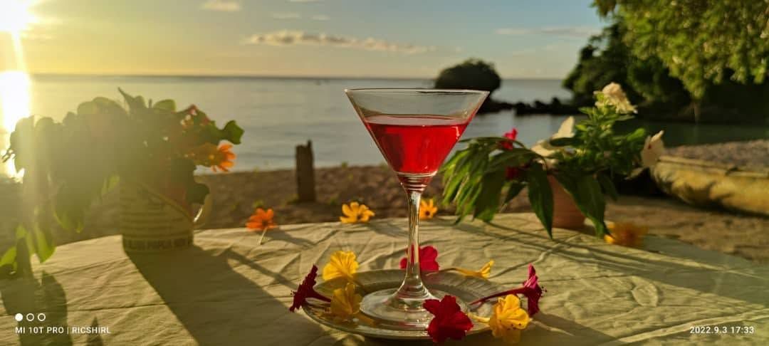 A sunset cocktail drink served on a decorated outdoor table.