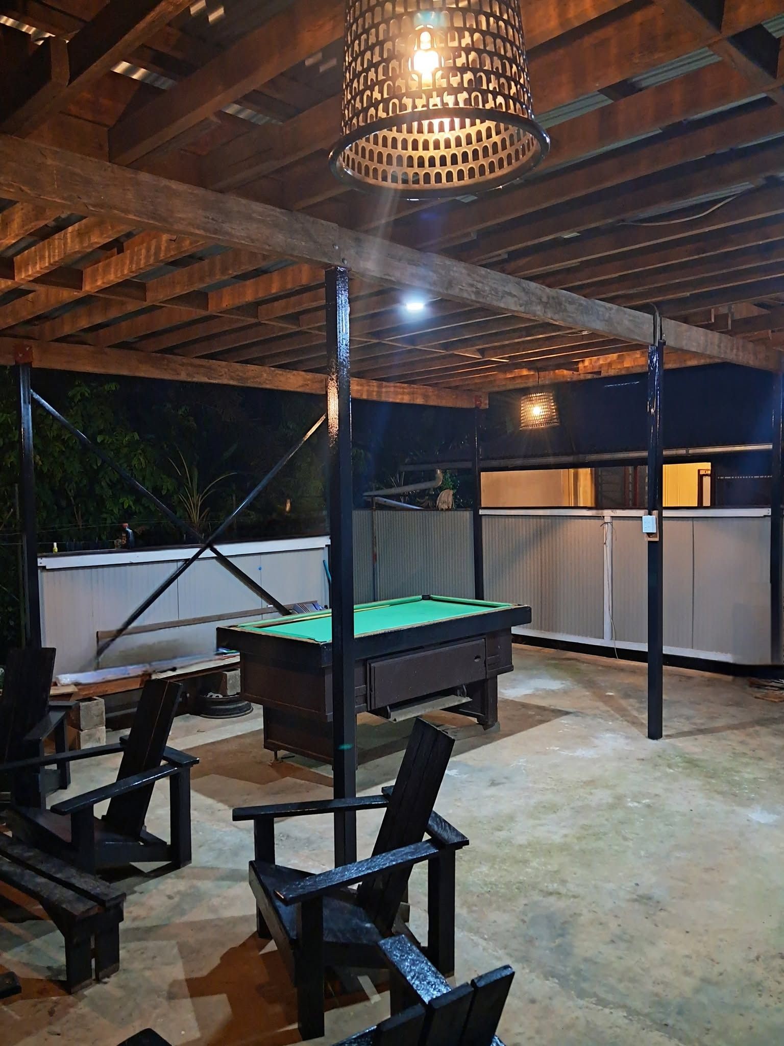Outdoor recreational area with a billiard table and wooden seating.