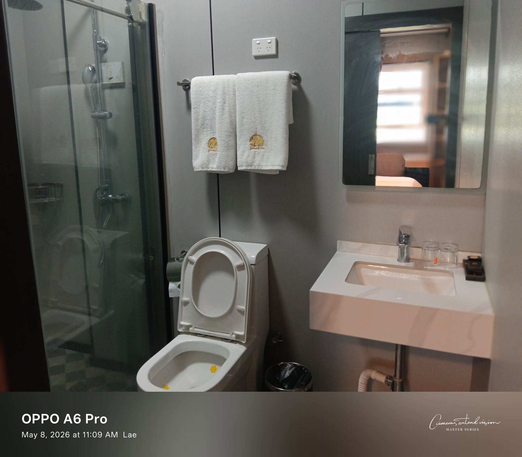 Bathroom interior with white towels, modern toilet, and sink area.