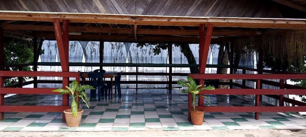 Outdoor sheltered seating area with tiled floor and beach view