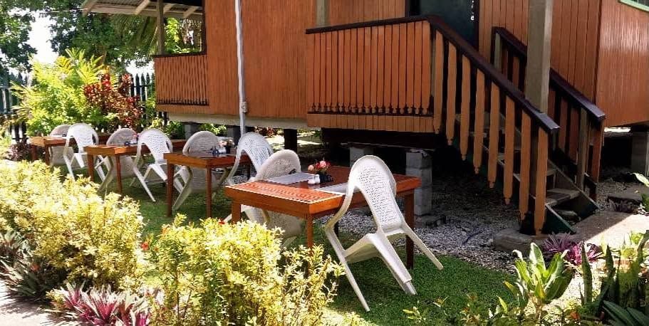 Outdoor dining area set up outside a wooden bungalow