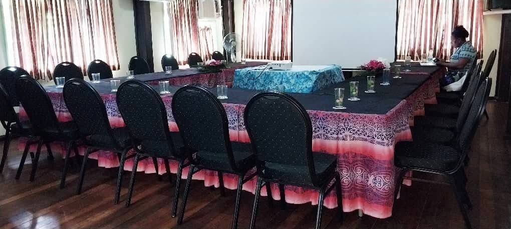 Conference or meeting room set up with U-shaped table and projector screen