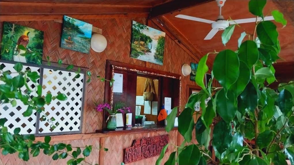 Wooden reception desk with island-style decor and wall art