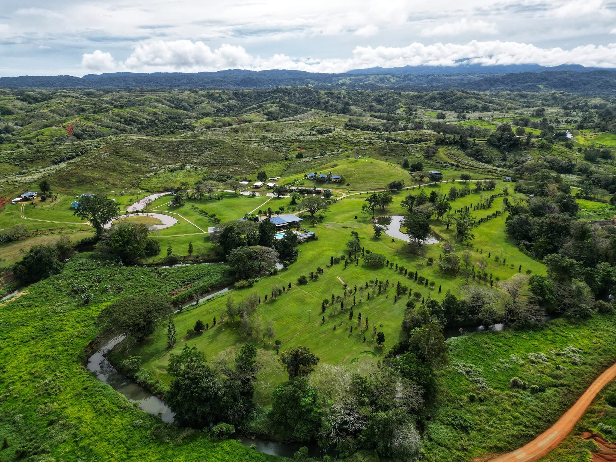 Aerial view of the country club estate including the river and hills.