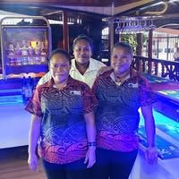 Service staff posing at the illuminated bar area with beverage displays.
