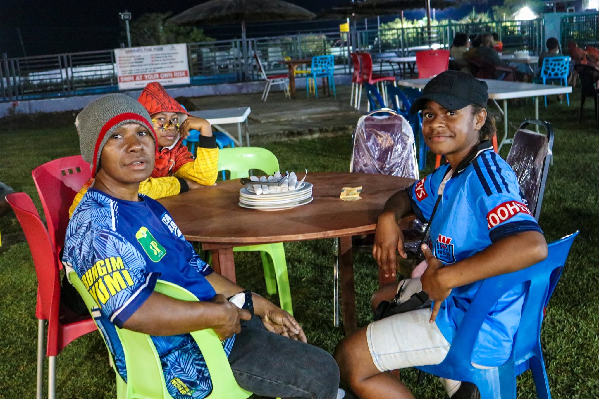 Patrons at a round table in the outdoor entertainment zone