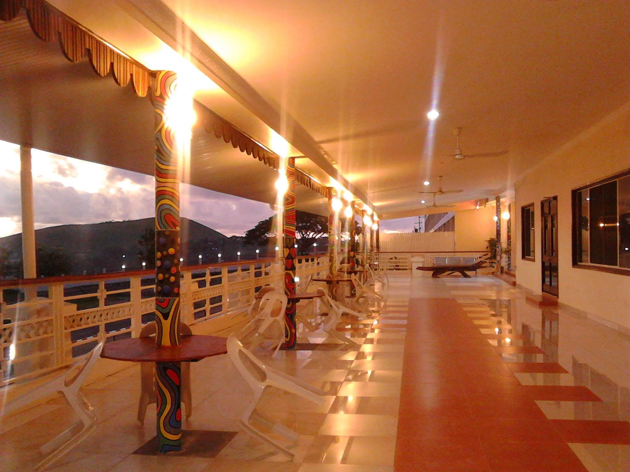 Outdoor covered terrace area with decorative pillars and sunset views.