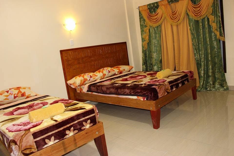 Twin bedroom with carved wooden headboards and elegant curtains.