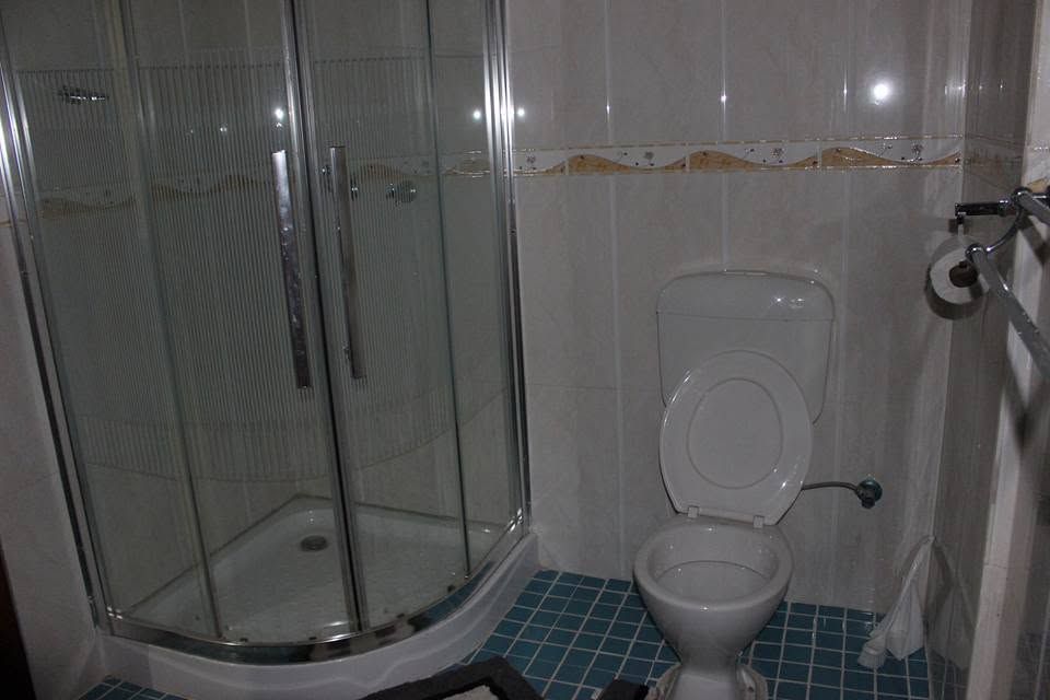 Clean bathroom with a corner glass shower and toilet utility.