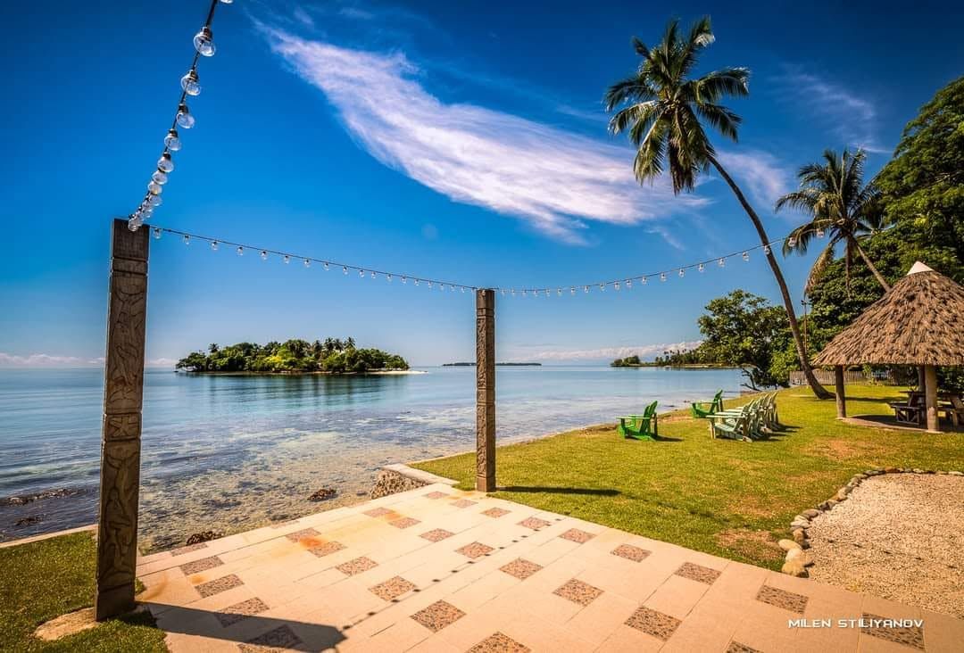 Paved patio viewing area with decorative poles overlooking the sea.
