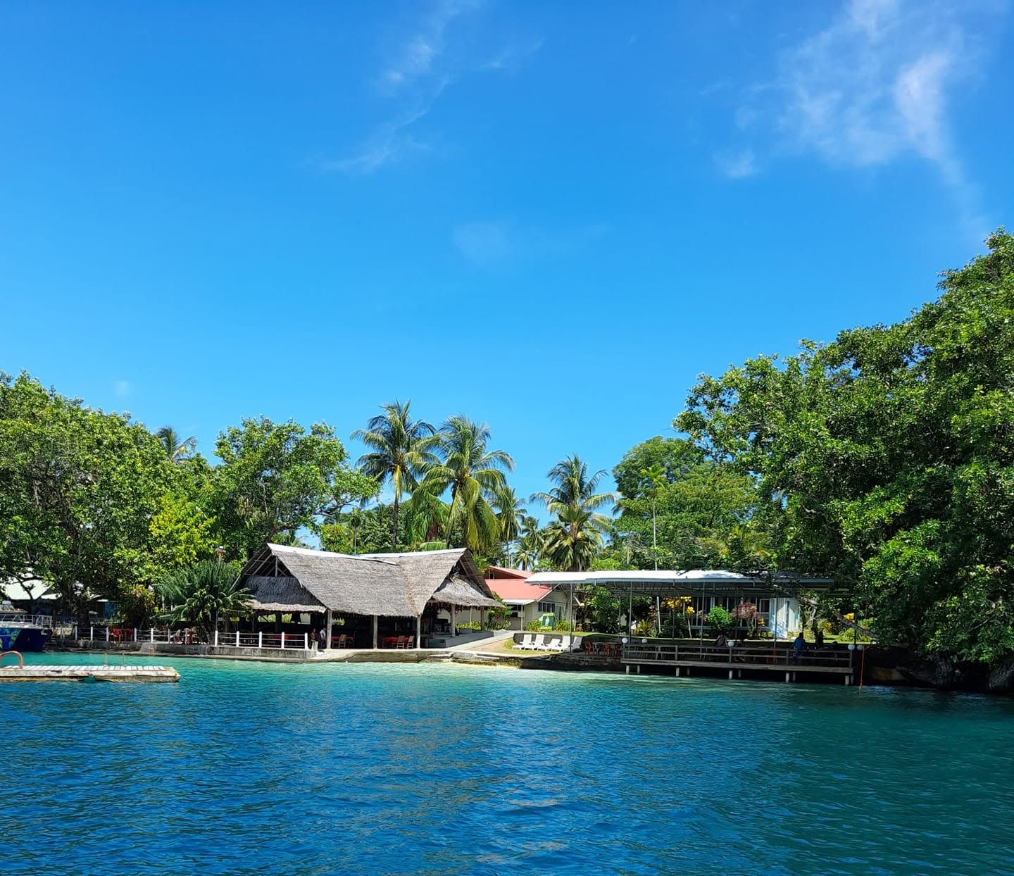 Waterfront view of the resort's thatched and modern structures.