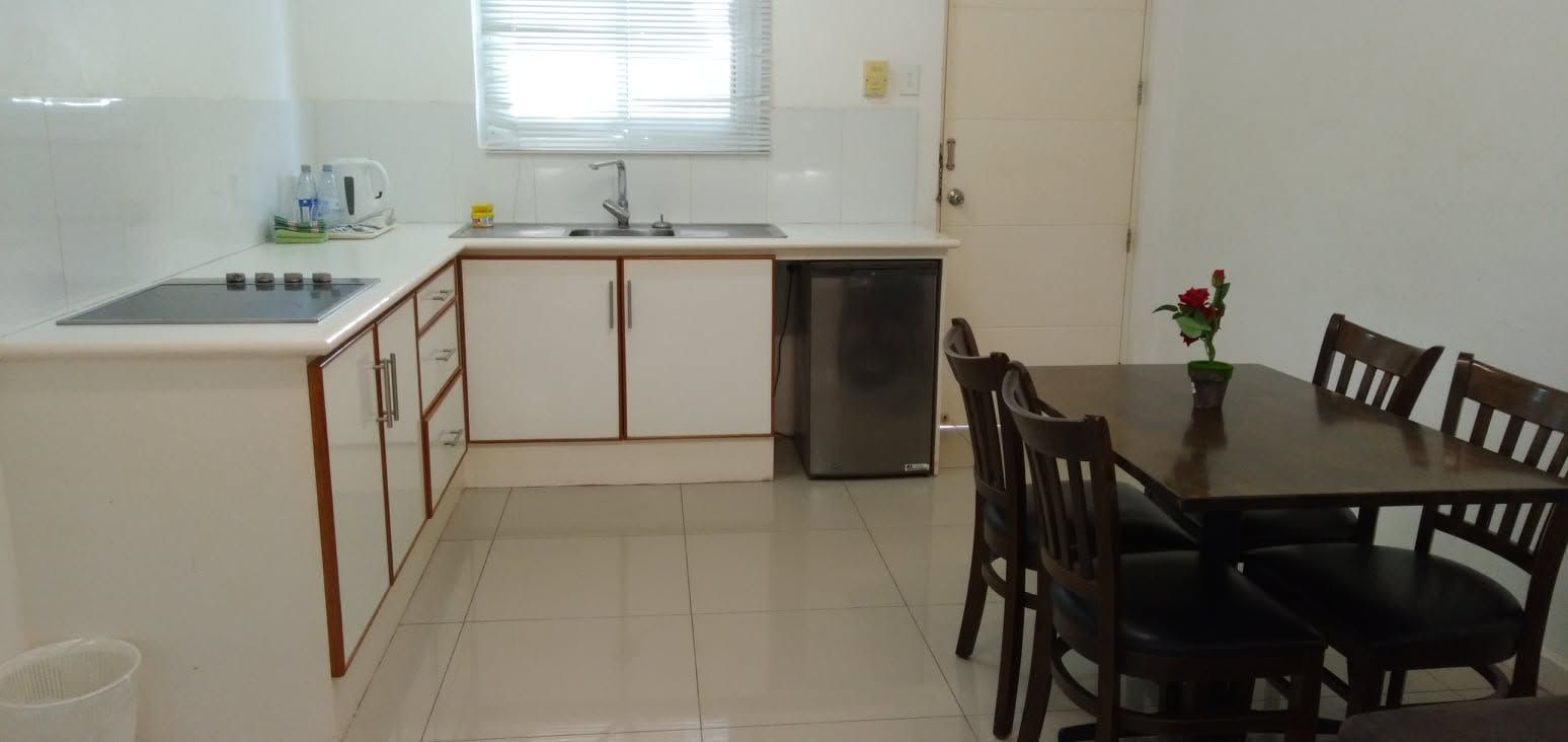 Fully equipped kitchen and dining area with modern white cabinetry.