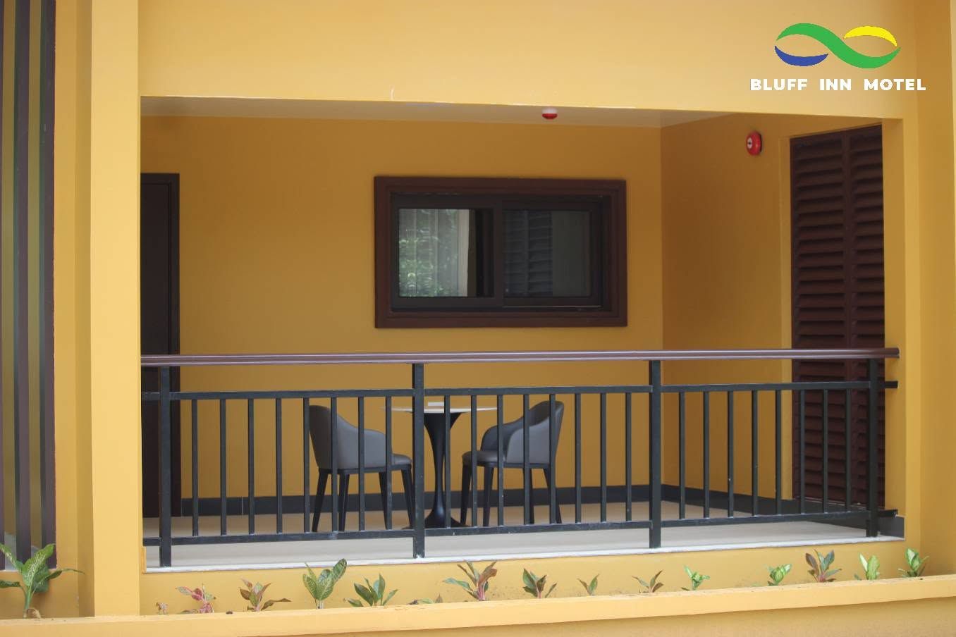 A private balcony with a small table and two modern chairs.