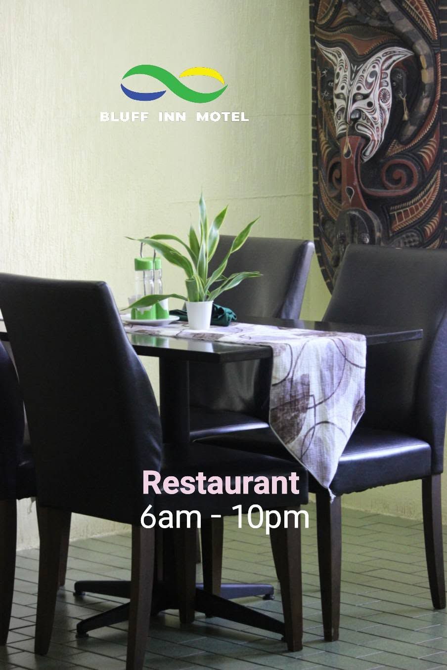Dining area with dark leather chairs and traditional artwork on the wall.