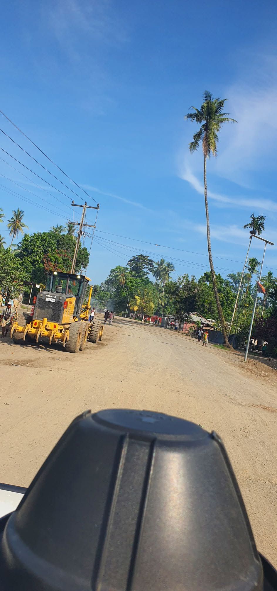 Unpaved road with construction machinery near the property location.