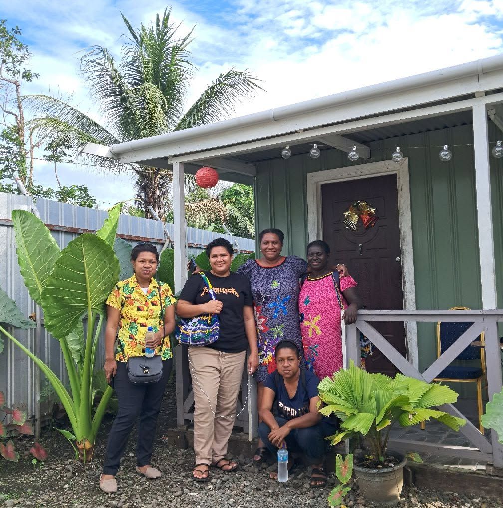 A group of people posing for a portrait in front of the building entrance.