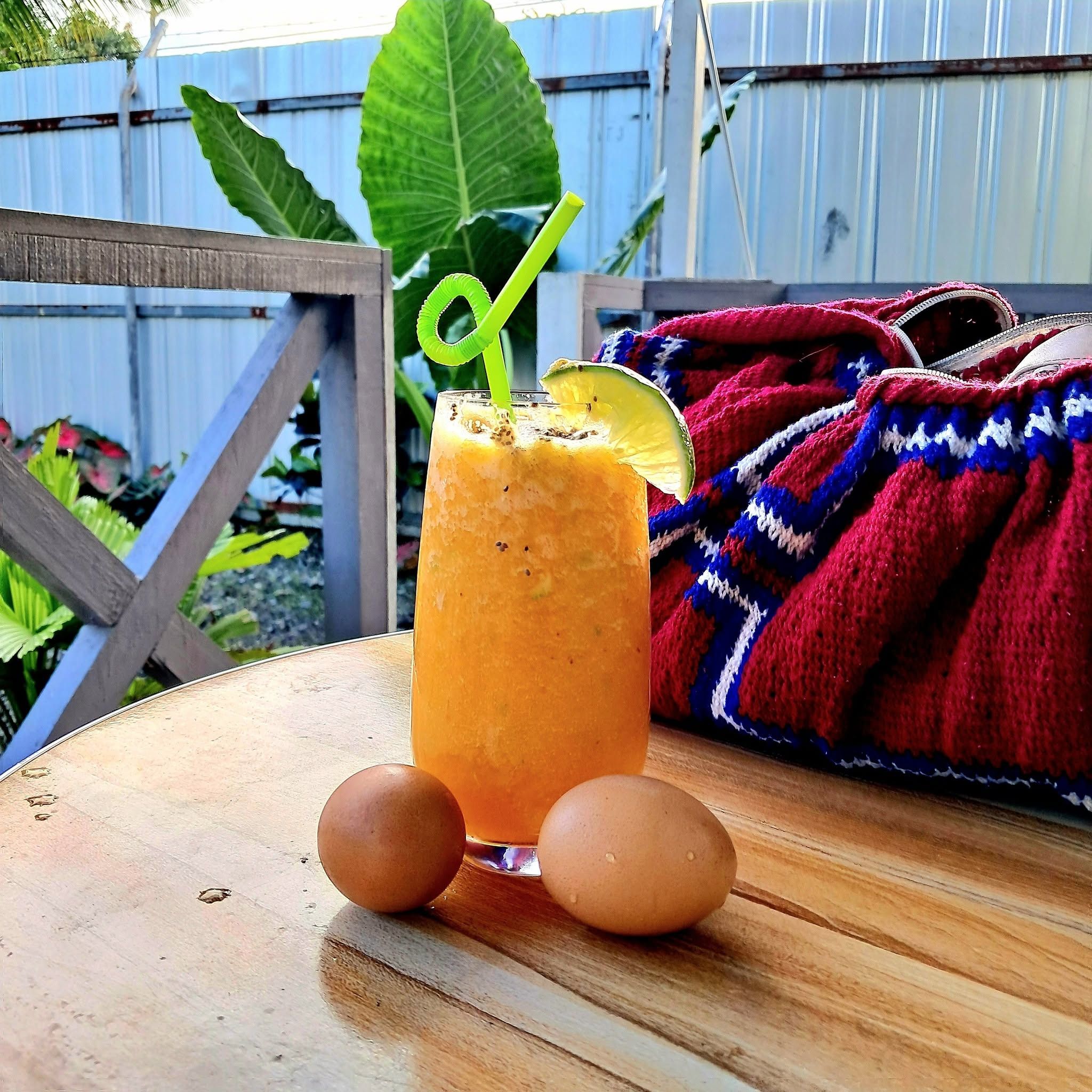 Fresh orange juice and breakfast eggs served on an outdoor table.