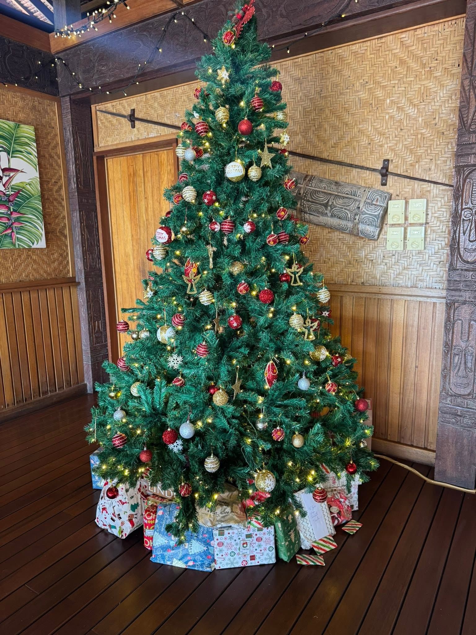 A decorated Christmas tree with presents in the resort lobby.
