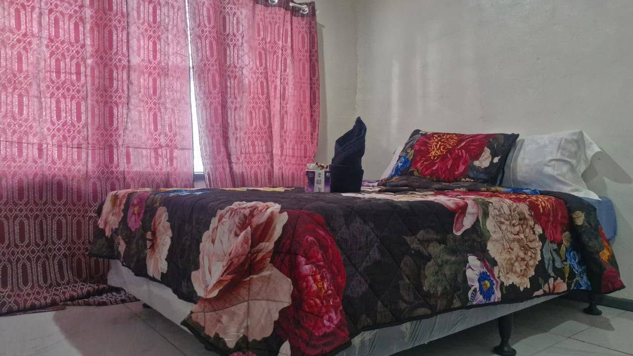 Close-up of a neatly made bed with floral patterned comforter