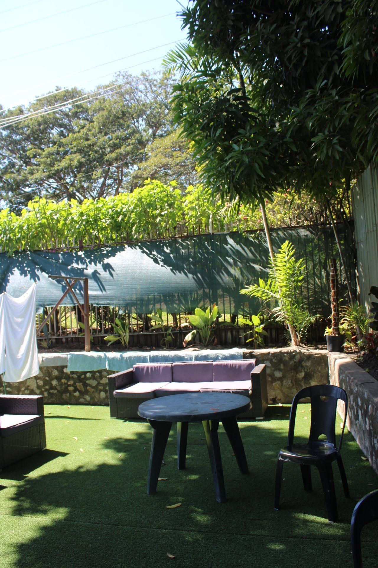 Outdoor seating area with a table and chairs on synthetic green turf