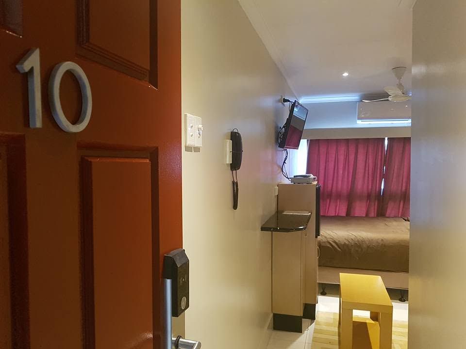 Entrance view into a numbered guest room showing the corridor and bedroom.