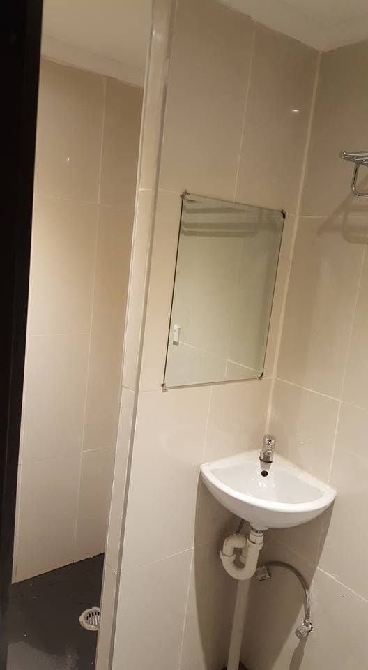Small guest bathroom area with white tiles and a simple mirror.