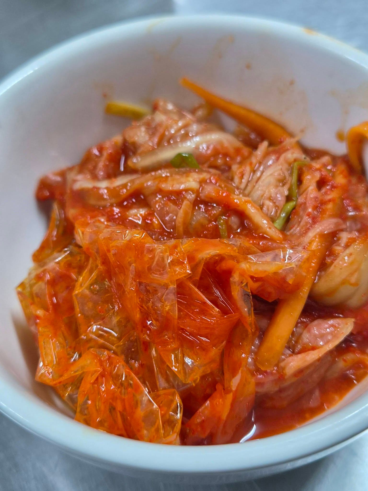 A close-up of a small bowl of spicy kimchi prepared at the restaurant.