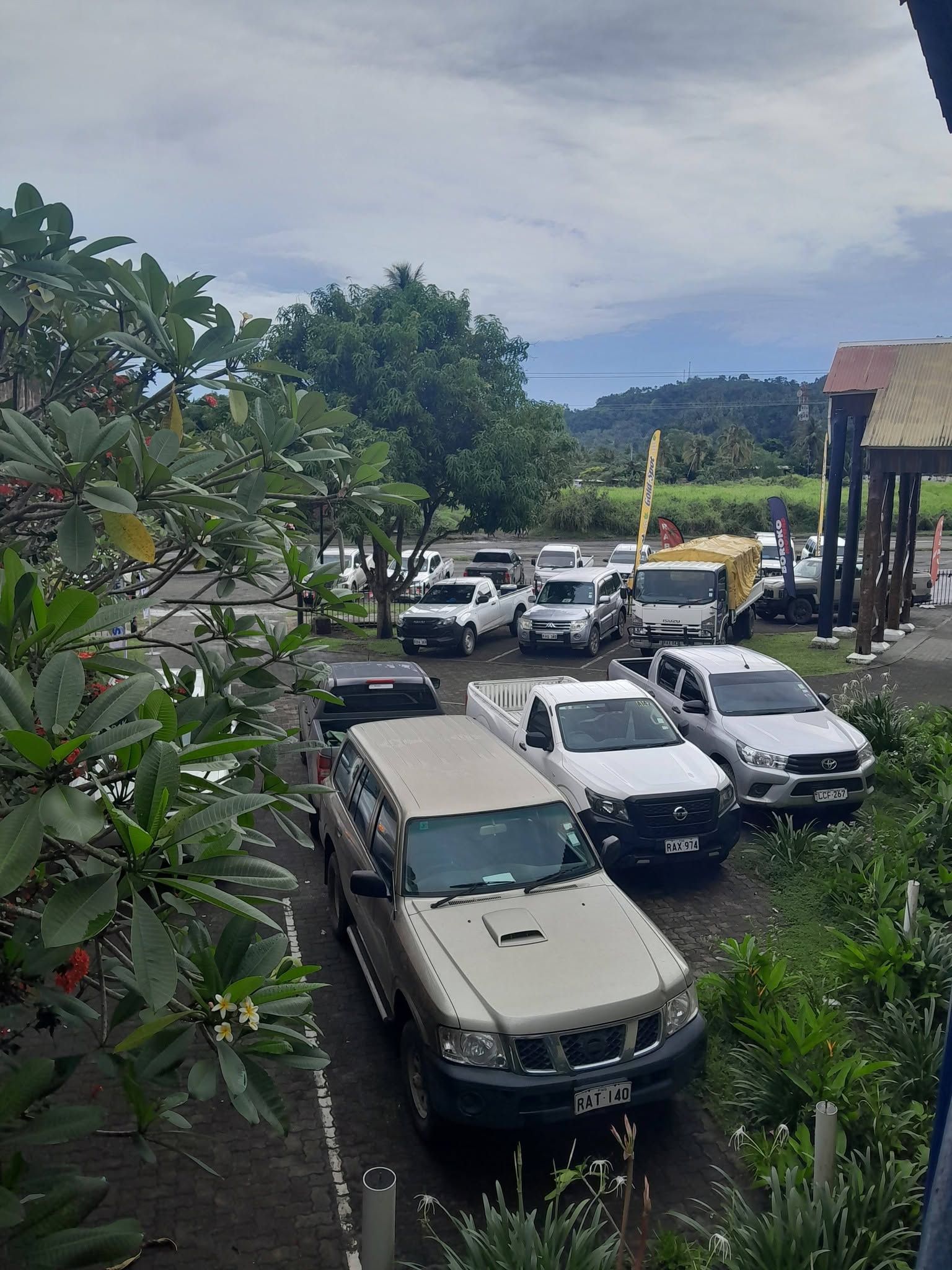 The hotel parking area surrounded by tropical greenery and trees.