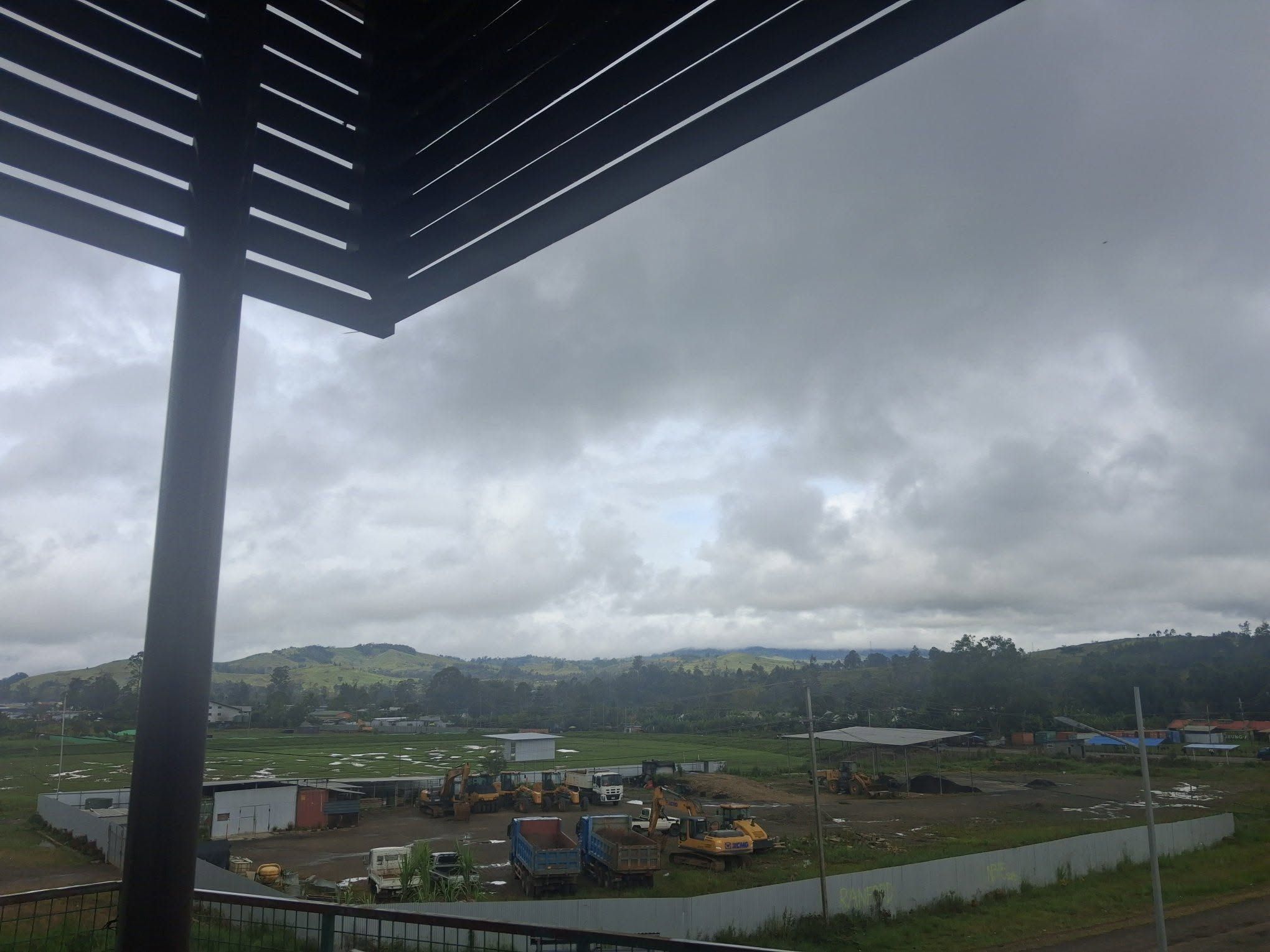 Overcast views of the industrial transit yard and distant hills.