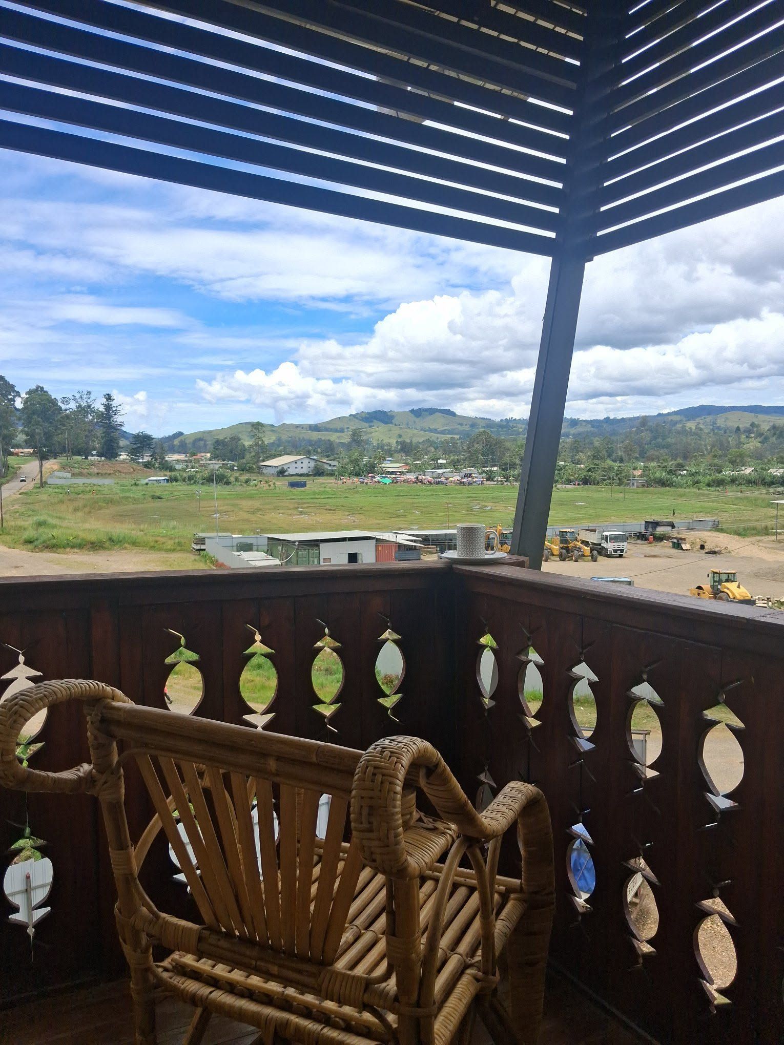 Rural landscape views from an upper-level wooden balcony.