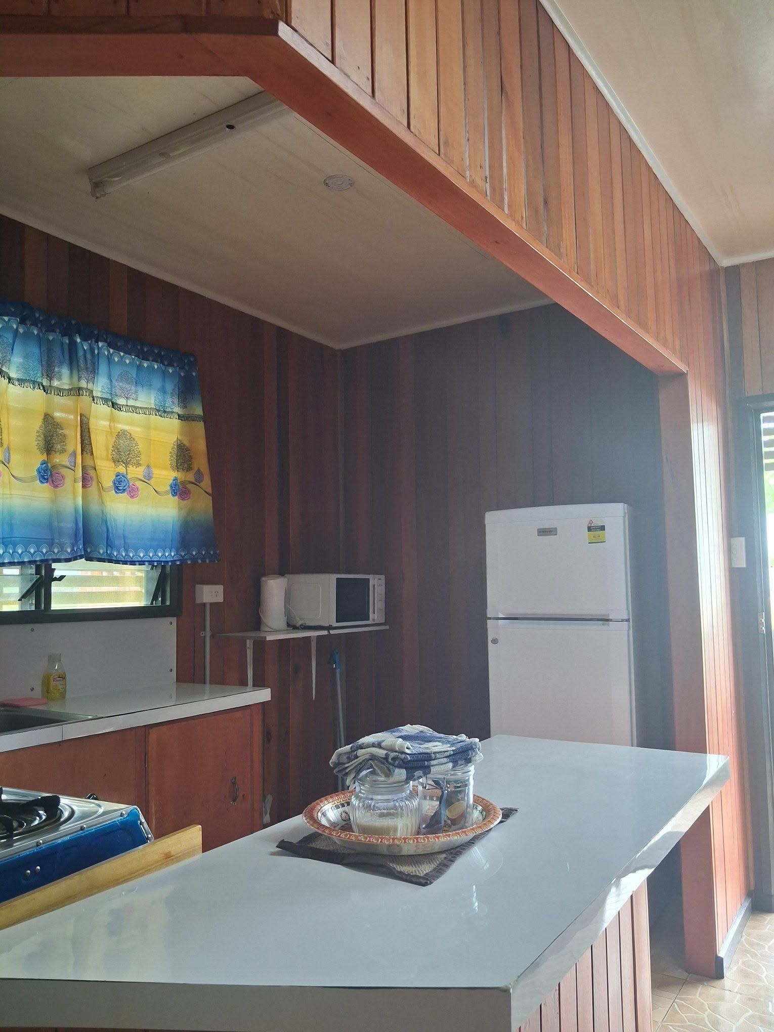 Kitchen space equipped with a microwave, fridge, and island counter.