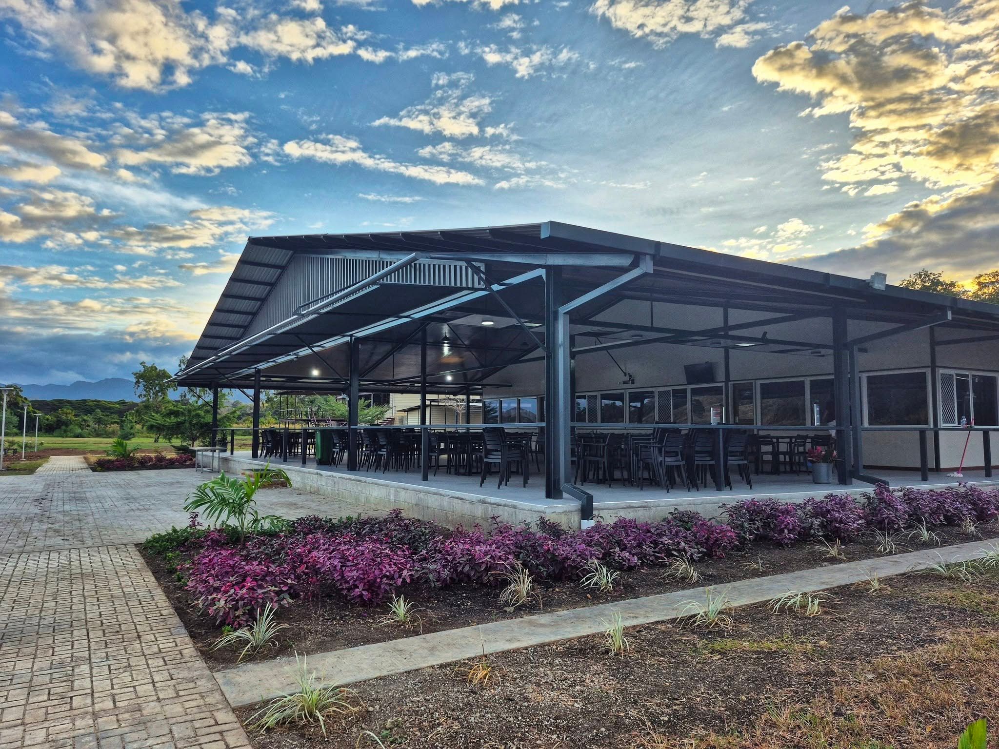 Spacious covered outdoor pavilion with numerous tables for group dining.