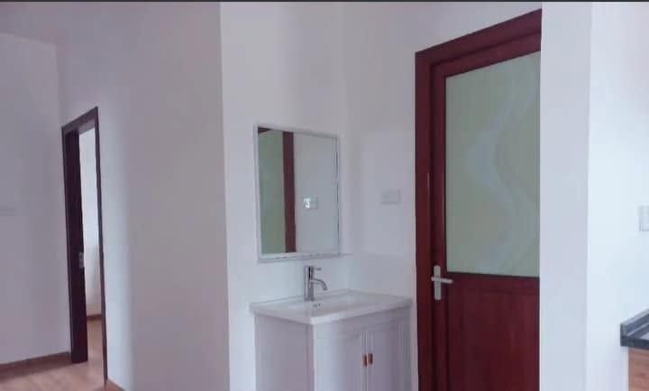 White vanity unit with sink and mirror located in a bright, modern interior room.