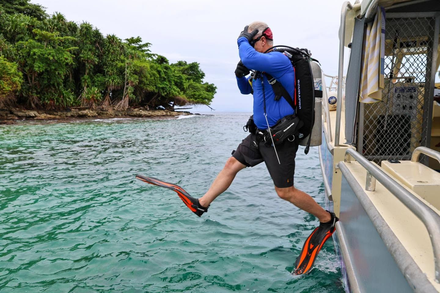 Diver making a giant stride entry into the ocean from a boat